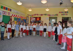 Dzieci z grupy V pozują do wspólnego zdjęcia. Dzieci są we większości przebrane w stroje w polskich kolorach narodowych. Ujęcie 2